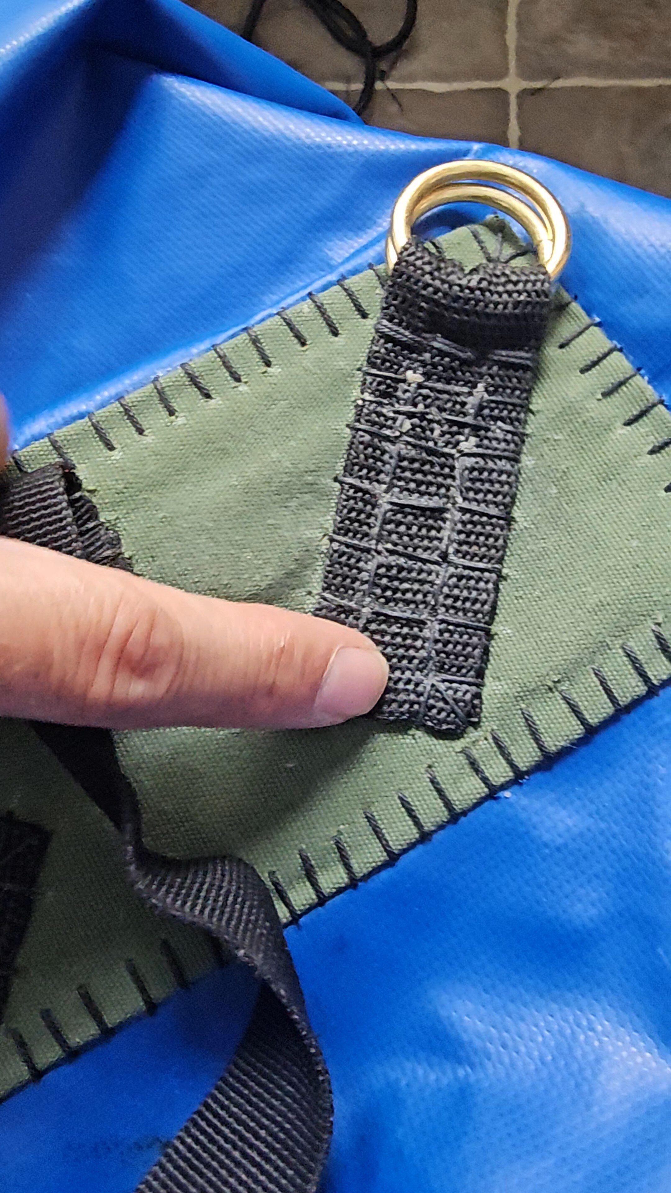 Doigt tenant une couture renforcée avec anneau de laiton fixé