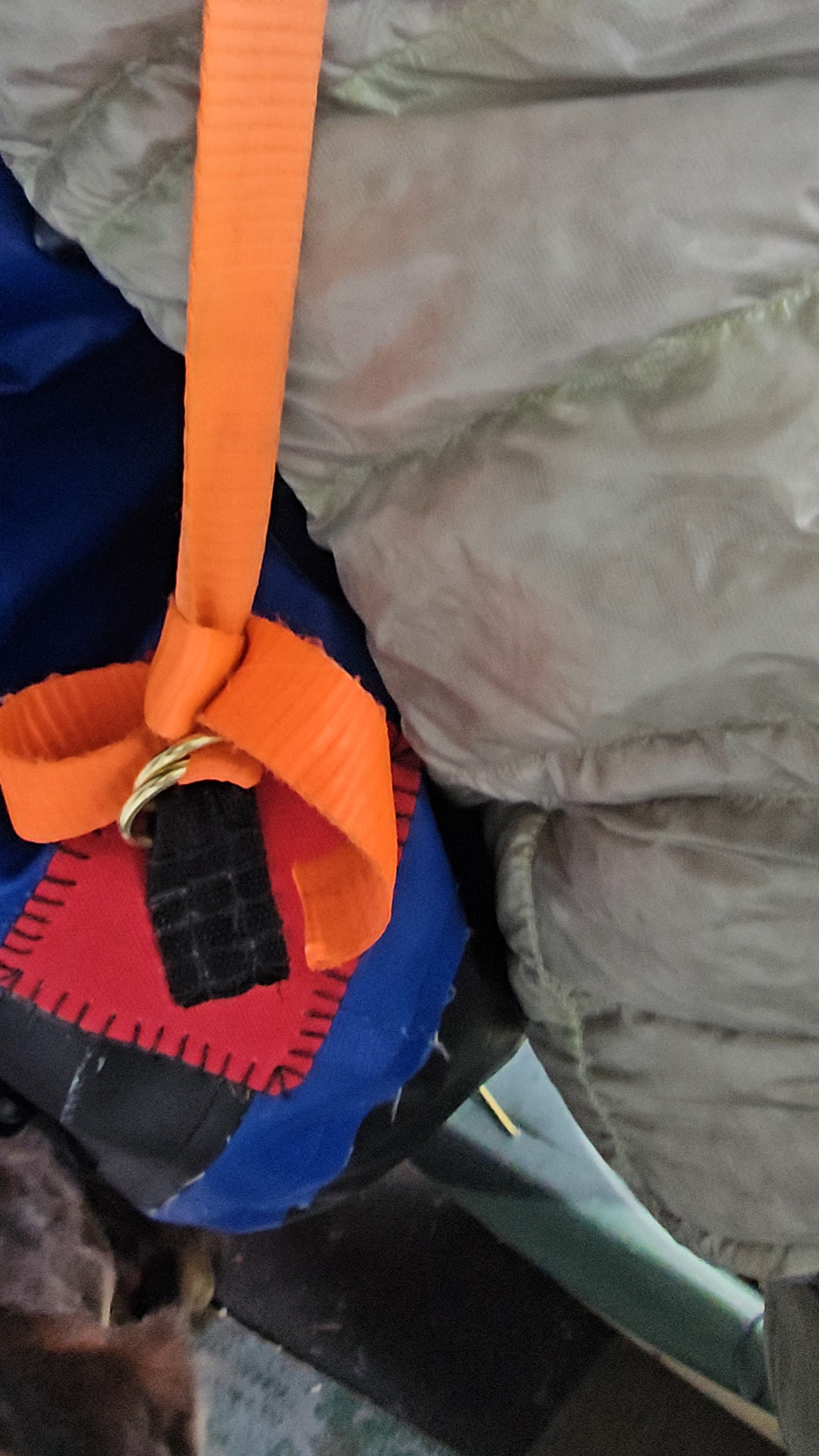 Détail d'une sangle orange cousue à la main avec pièce noire et rouge